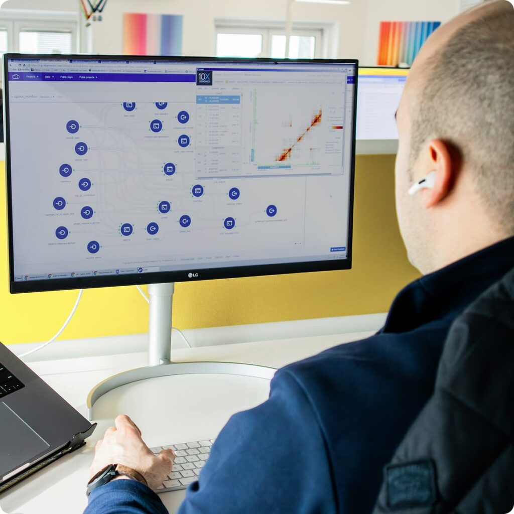 Person at desk viewing a complex node-based workflow and 10x Genomics data visualisation